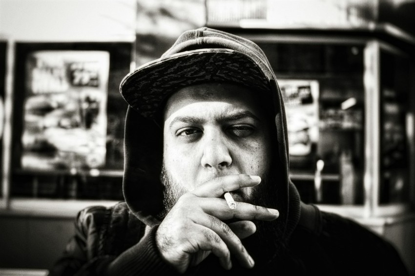 grayscale photography of man holding cigarette