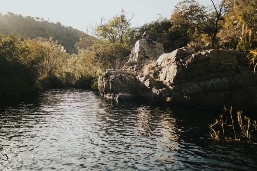 a man standing on a rock in the middle of a river