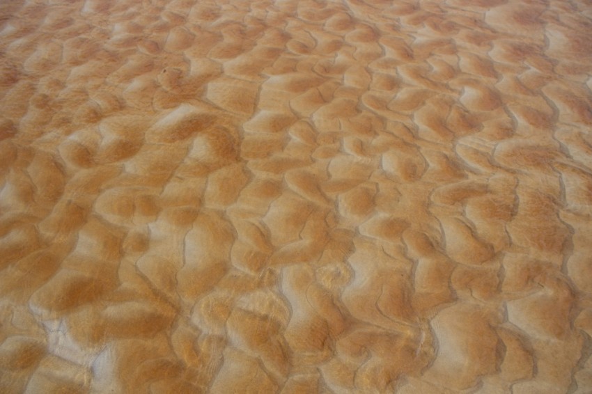 a plane is flying over a sandy area