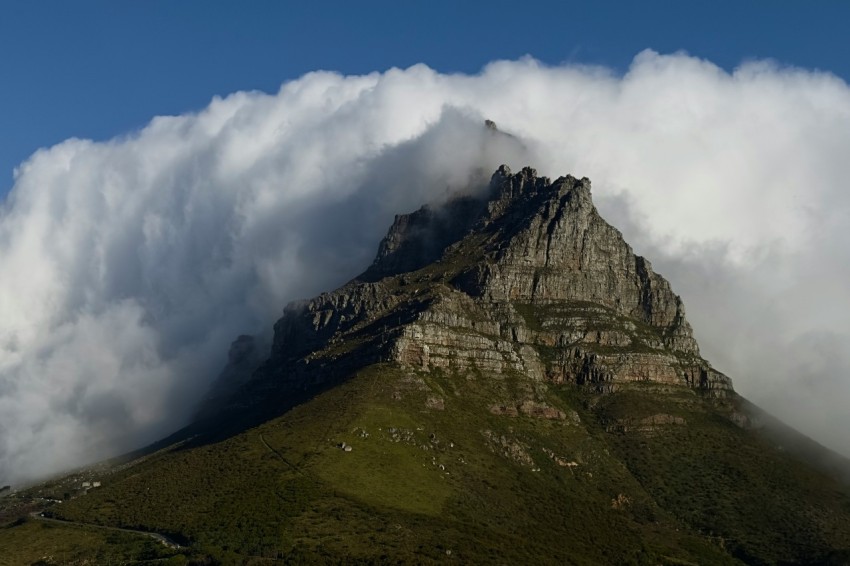 a very tall mountain with some clouds in the sky mgdButo