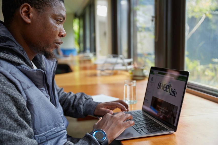 a man sitting at a table using a laptop computer