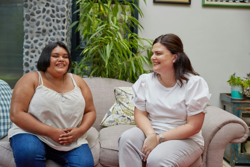 a couple of women sitting on top of a couch