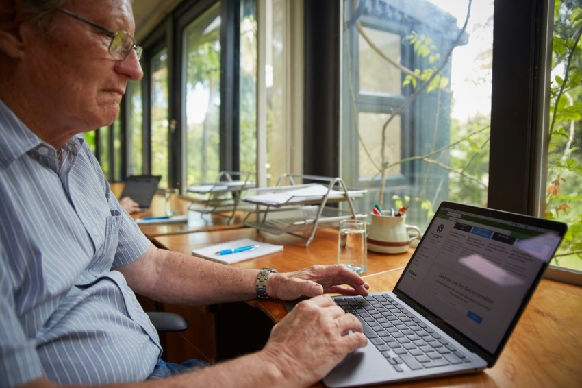 a man sitting at a table using a laptop computer