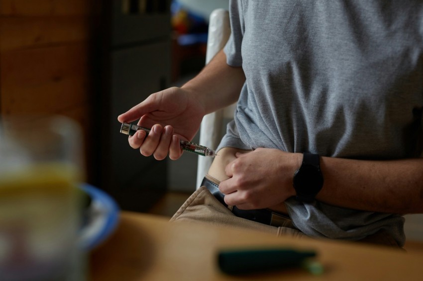 a person injecting insulin into stomach for diabetes management