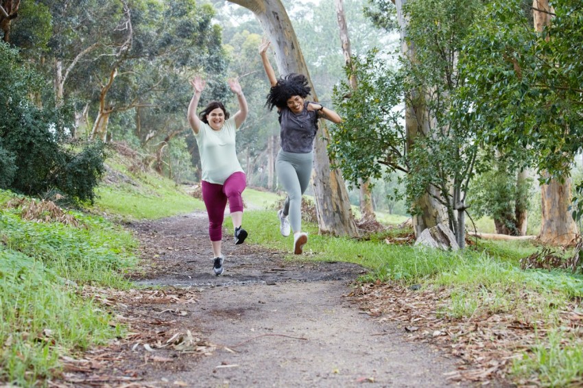 two women running down a path in the woods