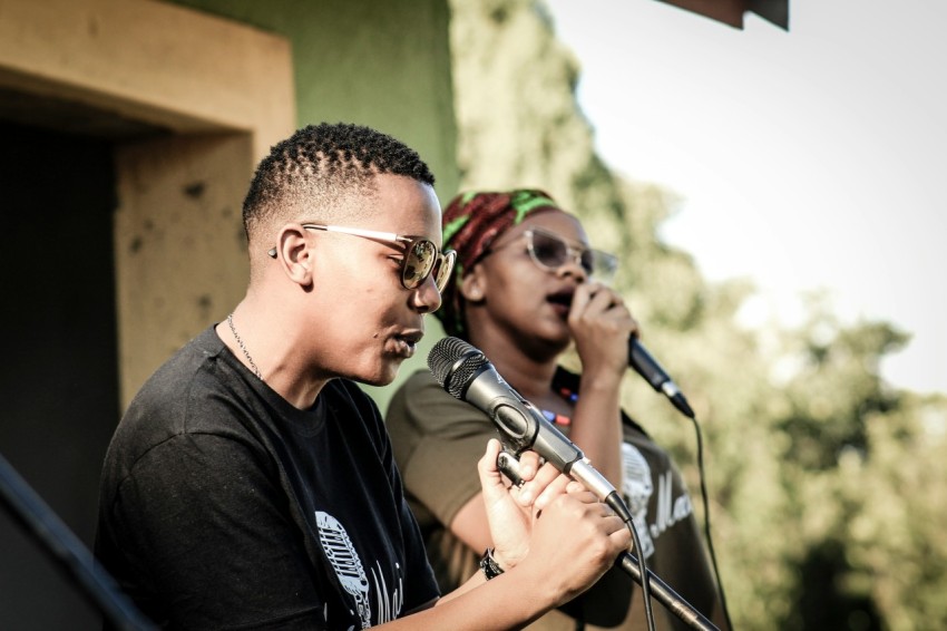 two persons holding microphones while talking c