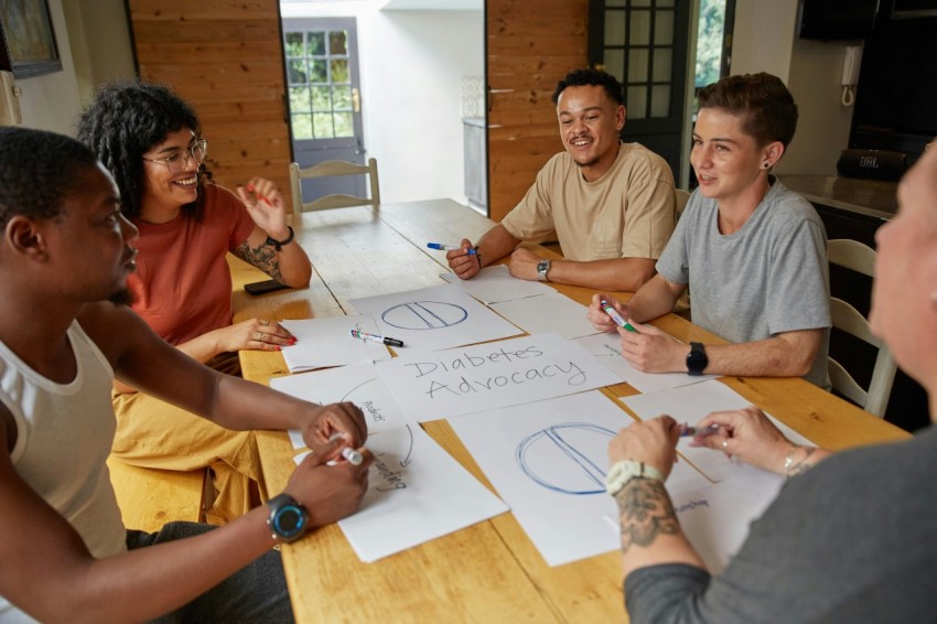 a group of people sitting around a wooden table