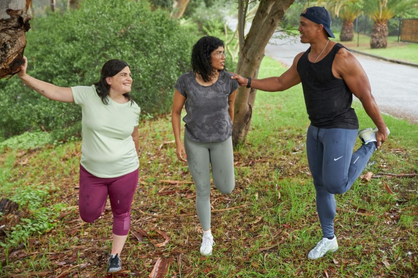 three people stretch before a run on a rainy day