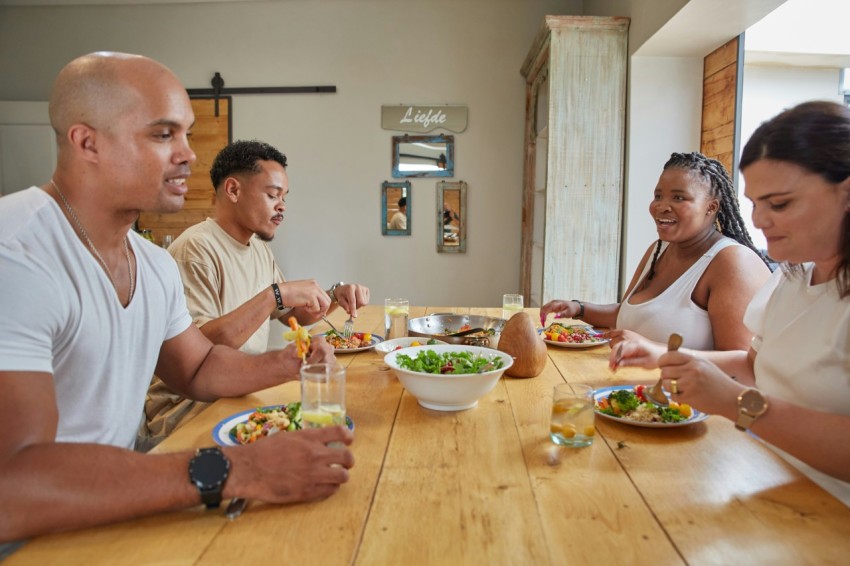 a group of people sitting around a table eating food