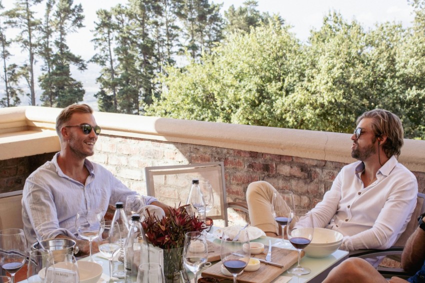 a group of men sitting at a table with wine glasses