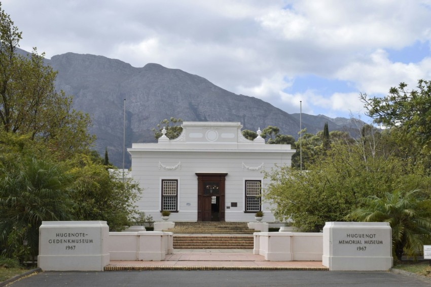 a white building with a mountain in the background YUOx