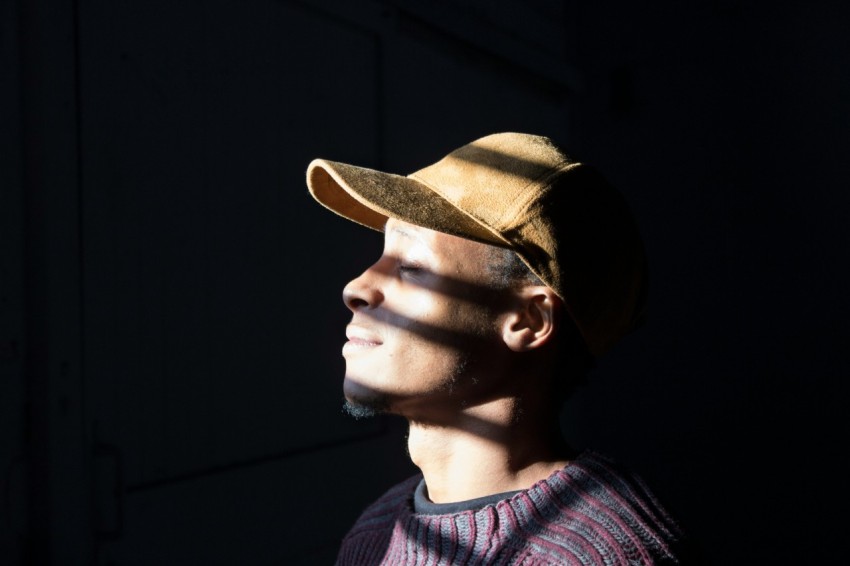 man standing wearing brown cap standing