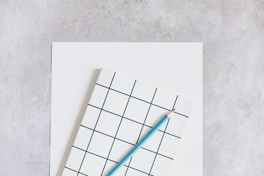 a blue pencil sitting on top of a piece of paper