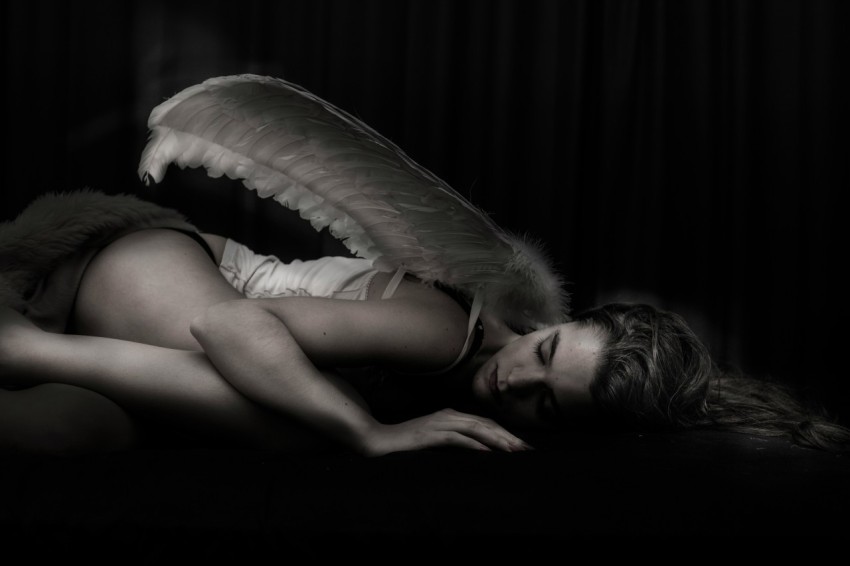 woman with angel wing lying on floor t3yr