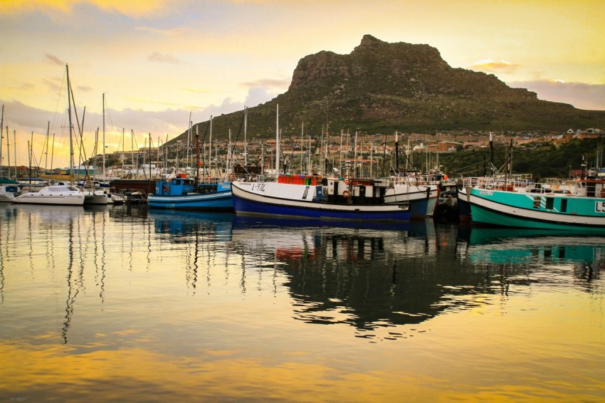 blue and white boat on water near mountain during daytime