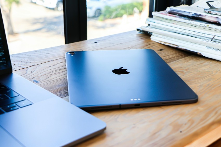 silver macbook on brown wooden table