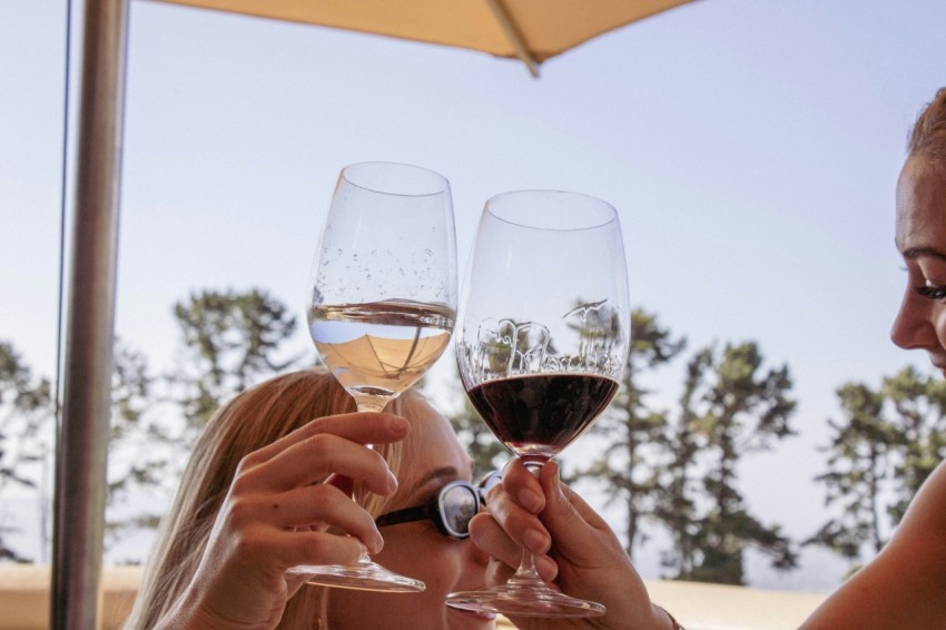 a woman holding a glass of wine in front of another woman