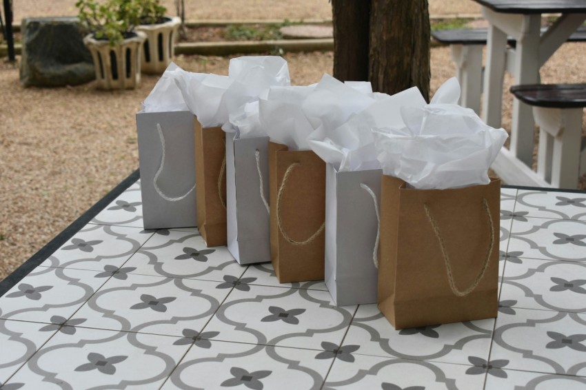 a table with three bags on it and a bench in the background