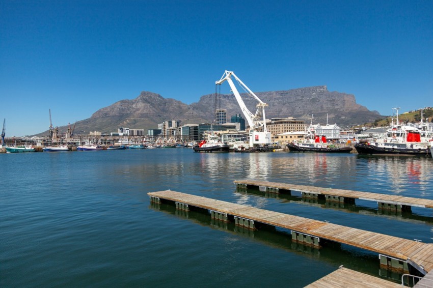 a body of water with boats and a crane in the background