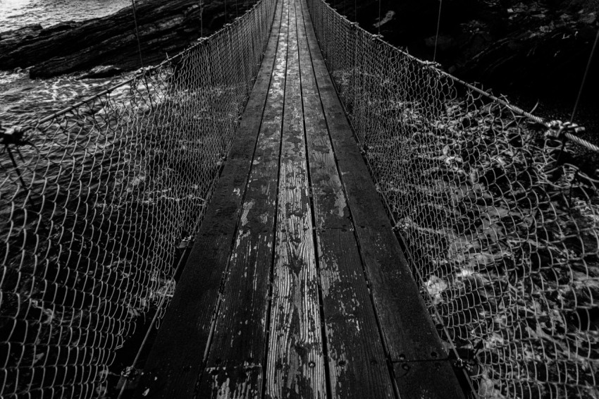 a black and white photo of a suspension bridge