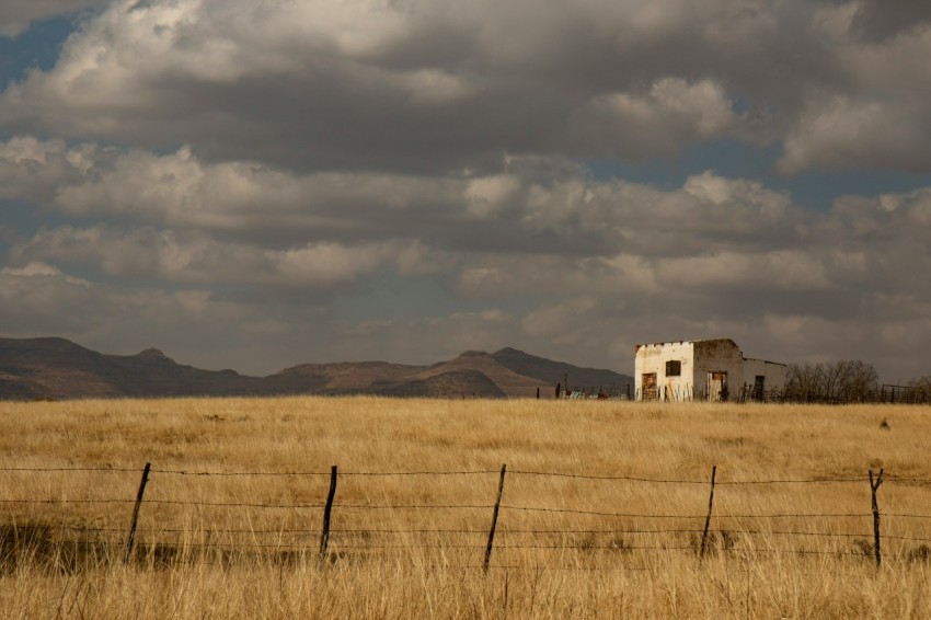 a house in a field with mountains in the background