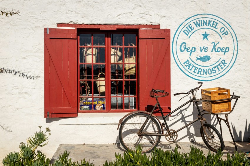 a bike parked in front of a building with red shutters