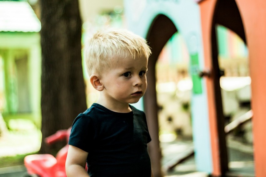 toddler in black crew neck t shirt standing beside wall