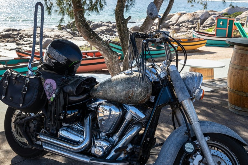 a motorcycle parked next to a tree near the water