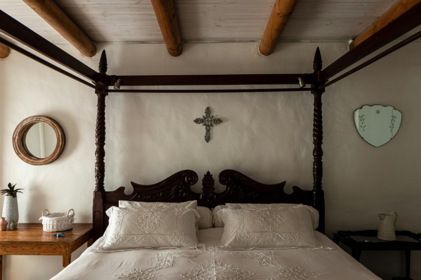 a bed with a cross on the wall above it