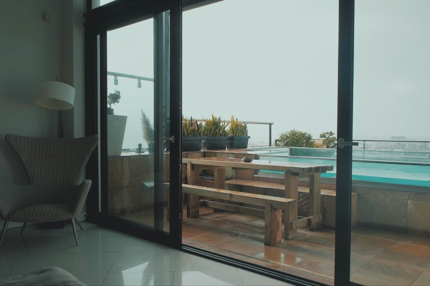 a patio with a table and chairs next to a swimming pool