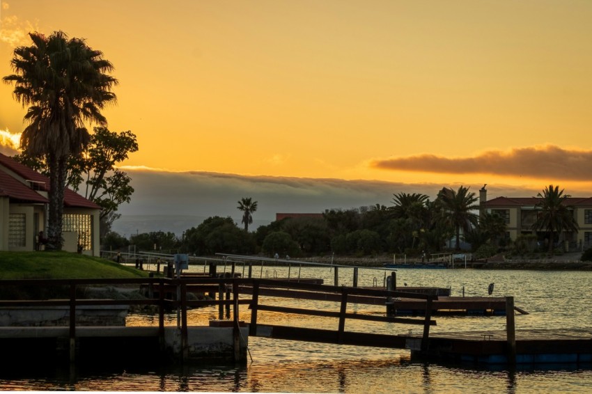 brown wooden dock on lake during sunset