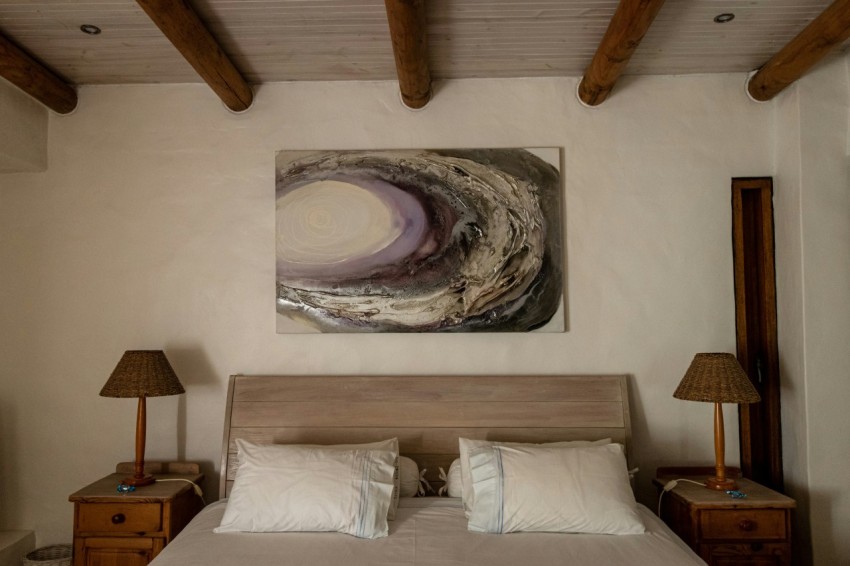 a bedroom with a bed and a painting on the wall