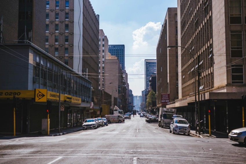 cars parked on side of road near high rise buildings during daytime