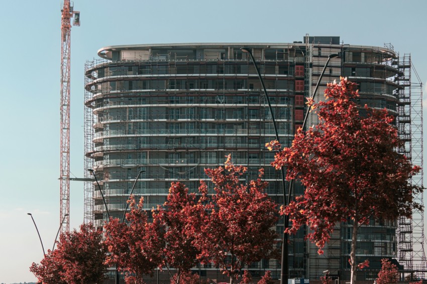 a tall building with a crane in the background