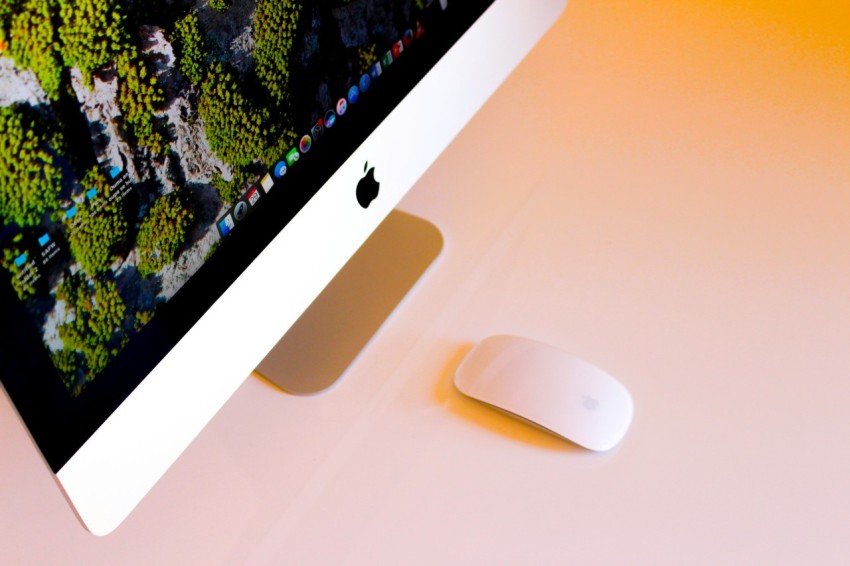 turned on silver imac beside apple magic mouse