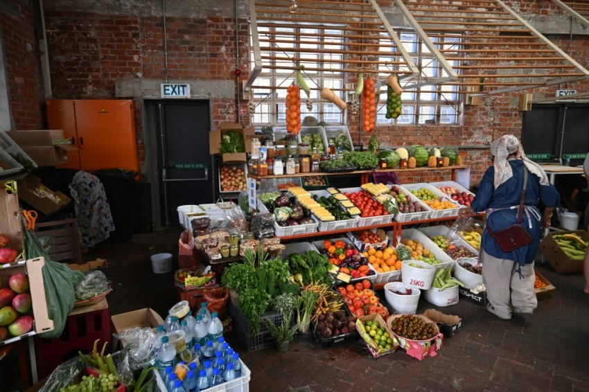 a woman standing in front of a display of fruits and vegetables