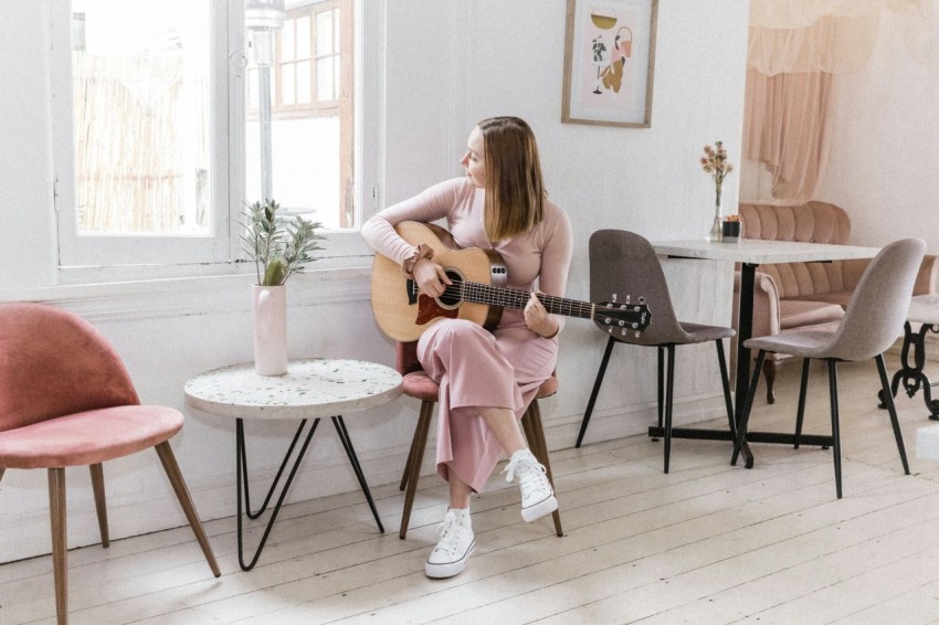 girl in pink dress playing guitar