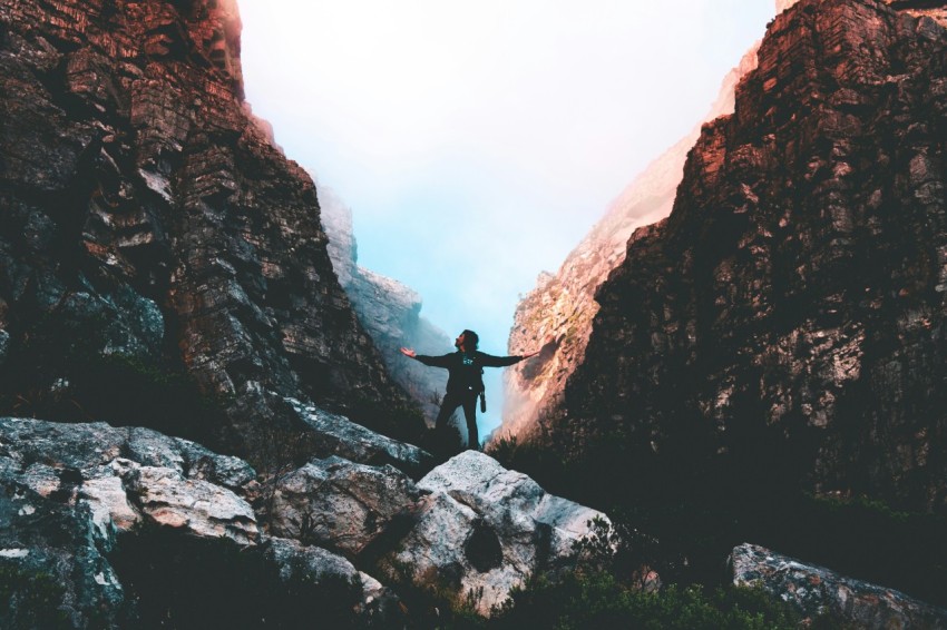 person in black jacket standing on rocky mountain during daytime vPvQwJI