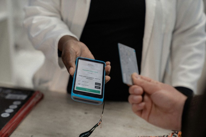 a person holding a smart phone and a credit card