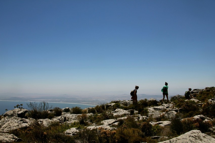 two people walking on rock formation at daytime