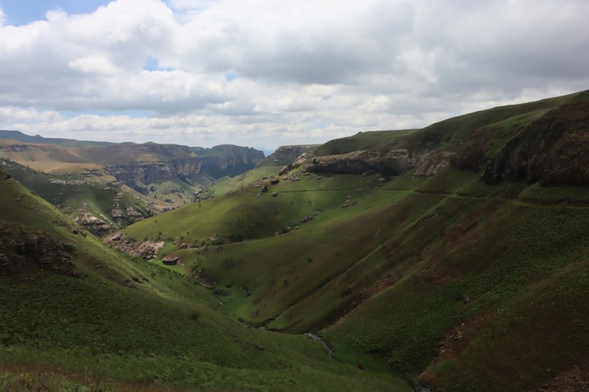 a green valley with mountains in the background