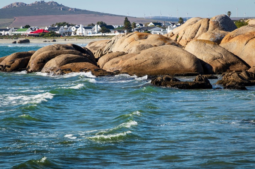 a group of large rocks sitting on top of a body of water qU