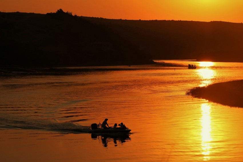 silhouette of people riding boat on sea during sunset 7_5NJd