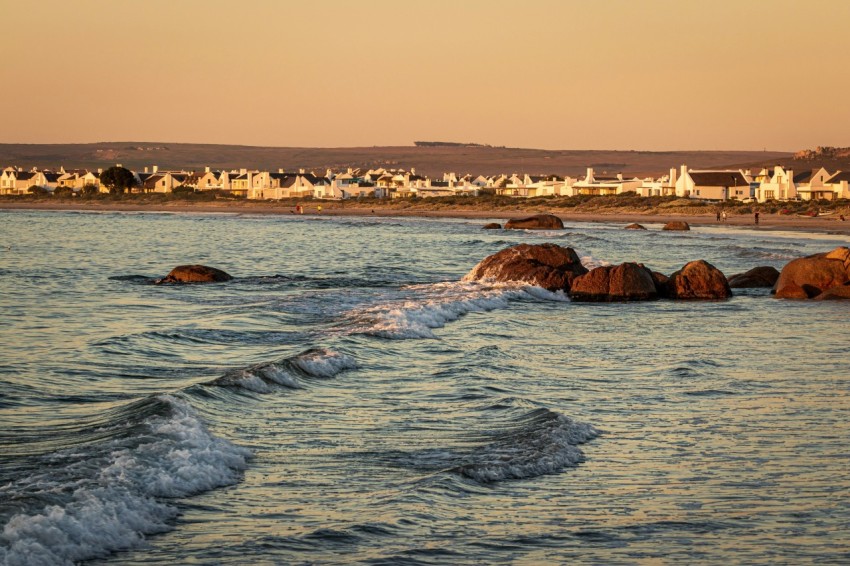 a body of water next to a sandy beach ASEf