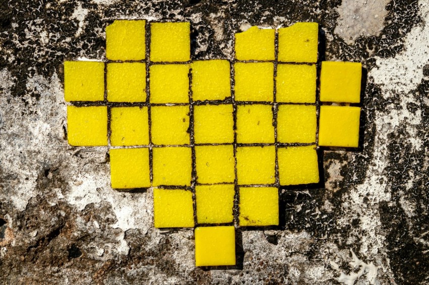 a heart made out of yellow squares on a rock