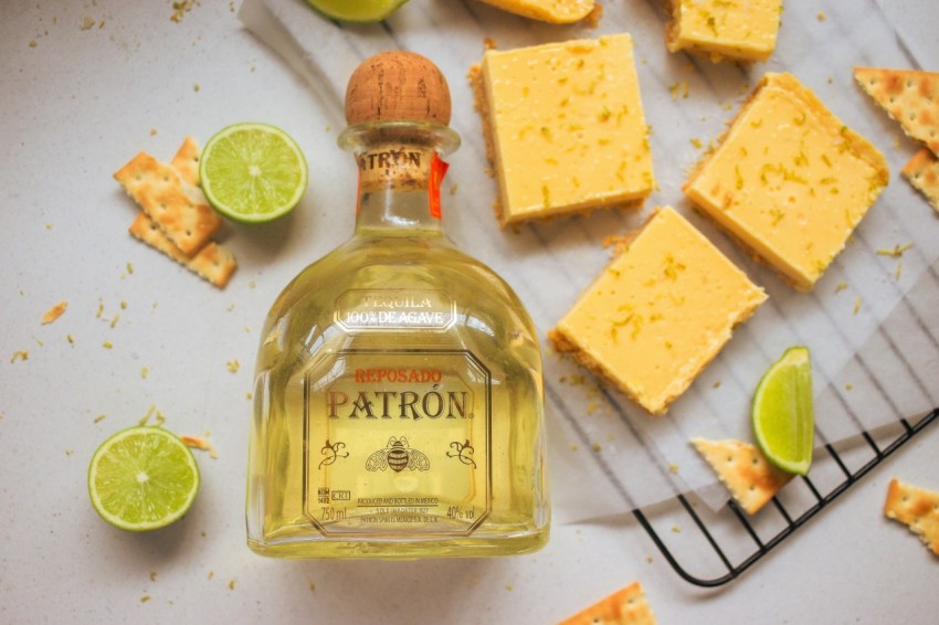 a bottle of patron with limes around it