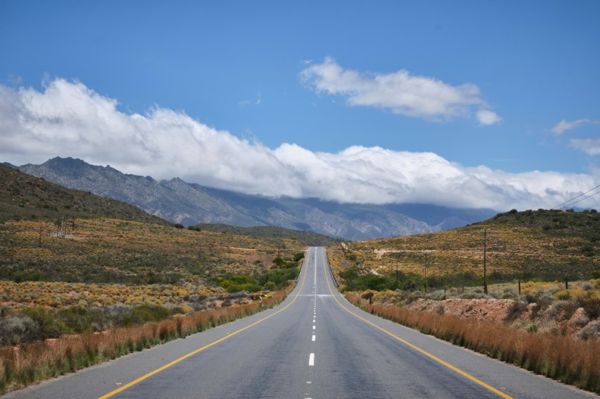 an empty road with mountains in the background