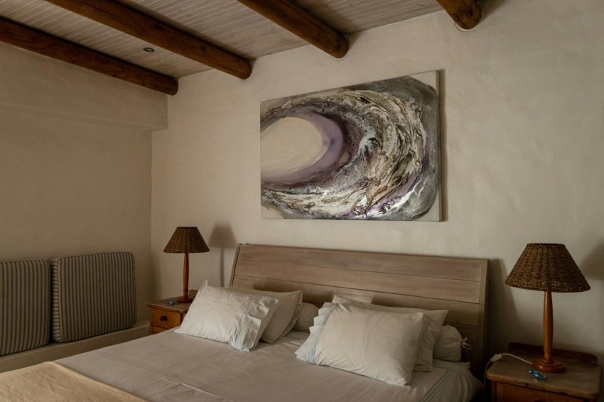 a bedroom with a bed and a painting on the wall