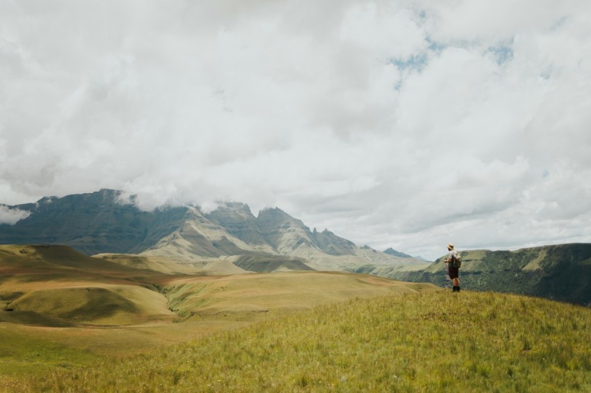 a man standing on top of a lush green hillside