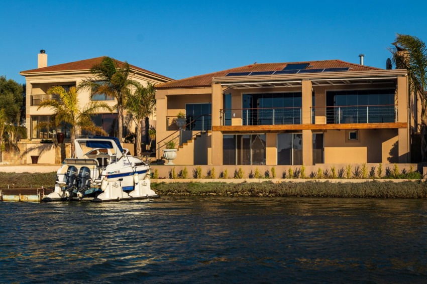 white and black motor boat on water near brown concrete building during daytime